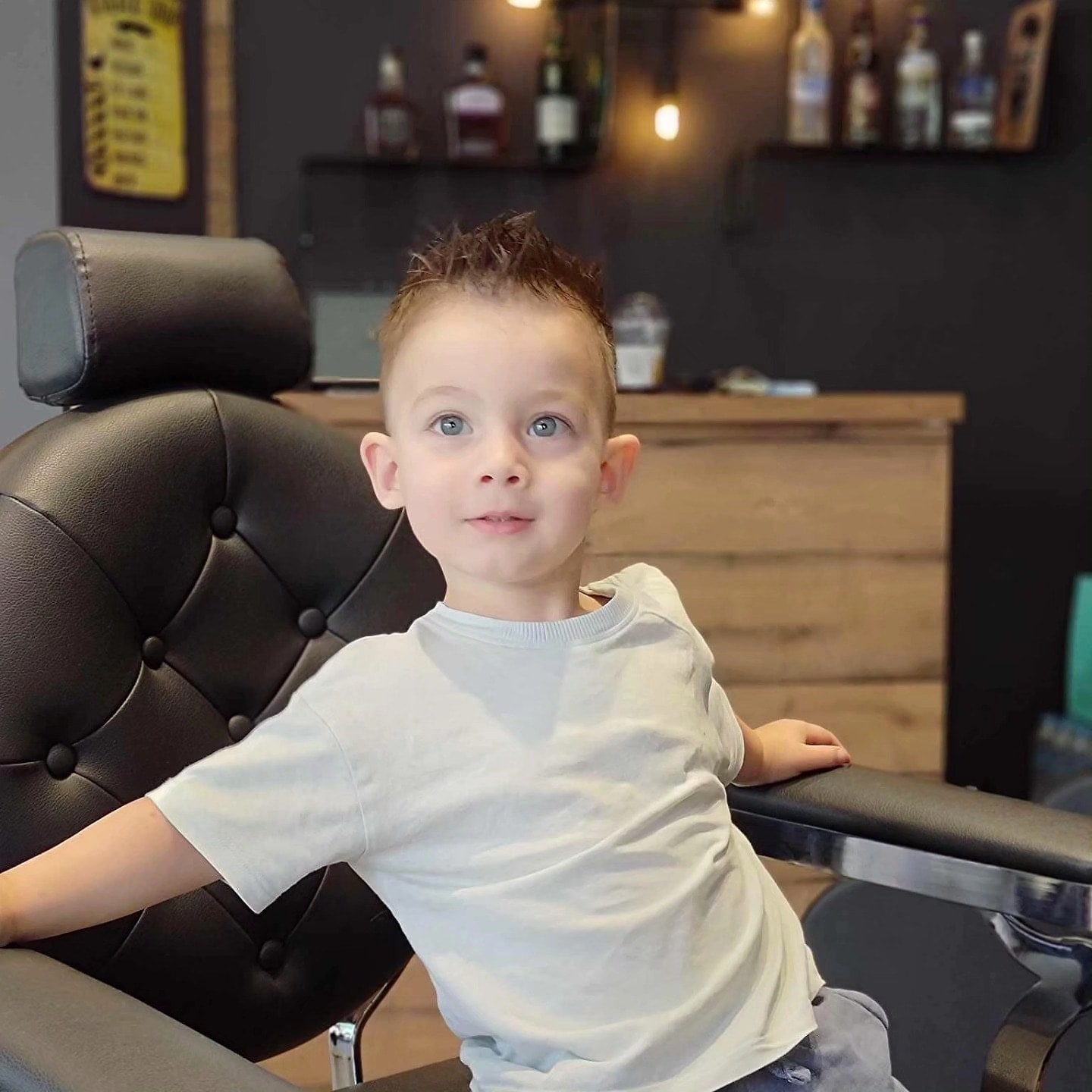 Μικρό αγόρι στην καρέκλα του The Barber Factory μετά το κούρεμα